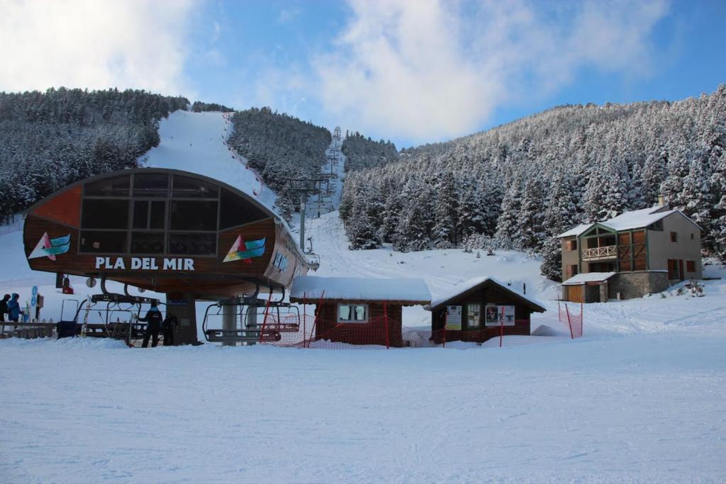 a building in the snow with a ski lift at Chalet Pla Del Mir in Les Angles
