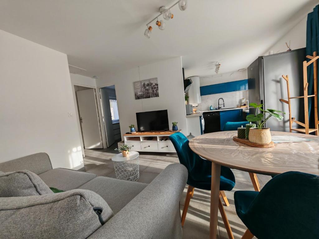 a living room with a table and a couch at Le cocon du Zoo de Beauval in Mareuil-sur-Cher