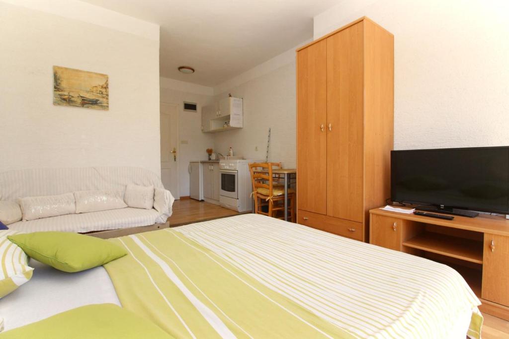 salon z łóżkiem i telewizorem z płaskim ekranem w obiekcie Apartments Mul w Bašce