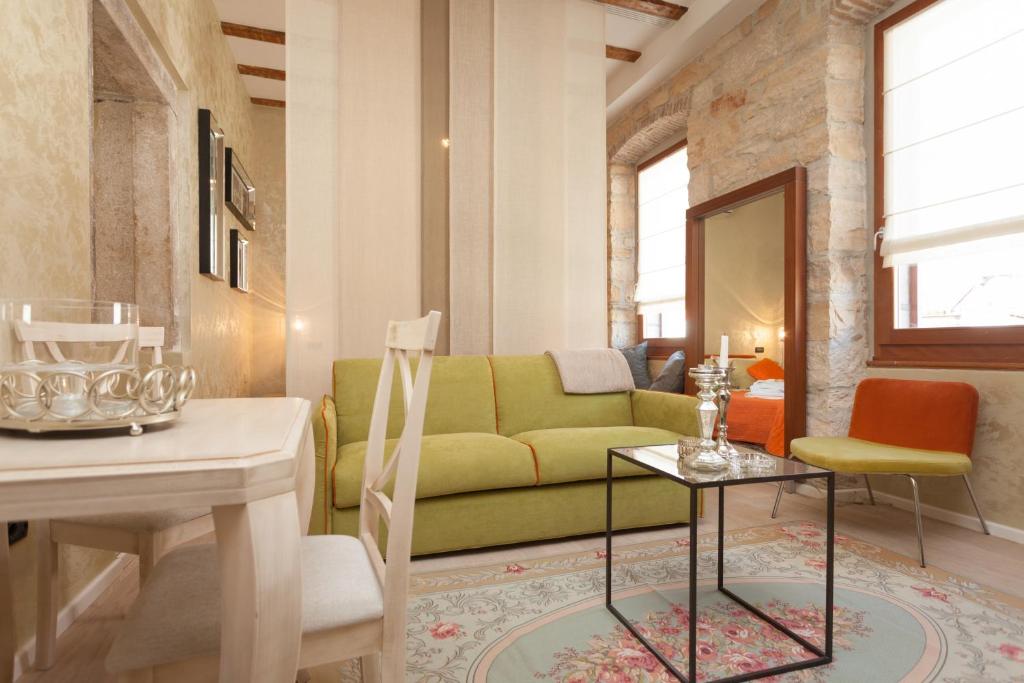 a living room with a green couch and a table at Apartment Lux Rovinj in Rovinj