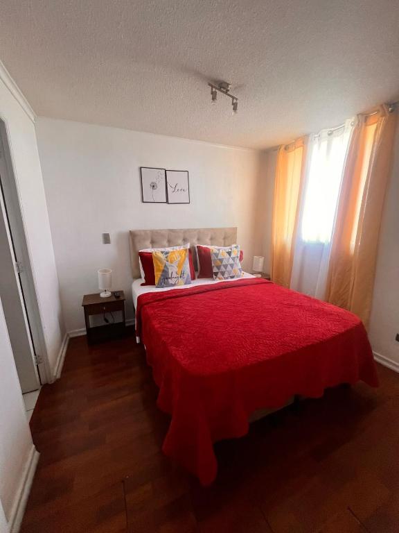 a bedroom with a red bed with a red blanket at Departamento bellas artes in Santiago