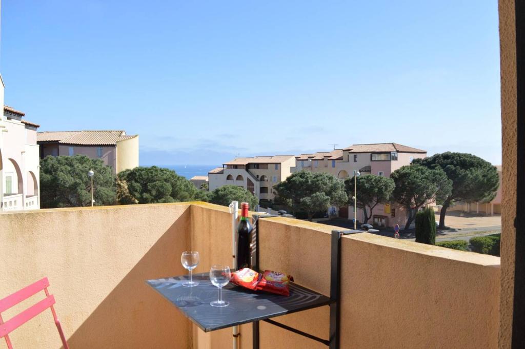 - une table sur un balcon avec bouteilles de vin et verres dans l'établissement SP520-K227 Appt 2 pièces cabine 4 couchages SAINT PIERRE LA MER, à Saint Pierre La Mer