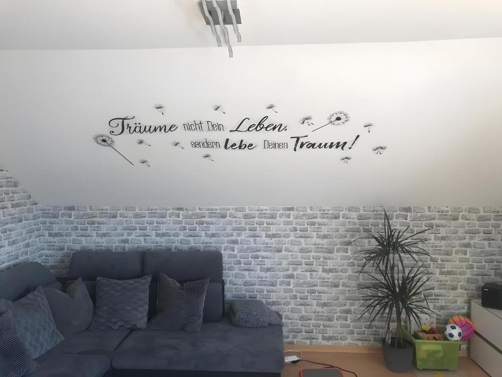 a living room with a couch and a brick wall at Fewowe Ferienwohnung Wenden in Wenden
