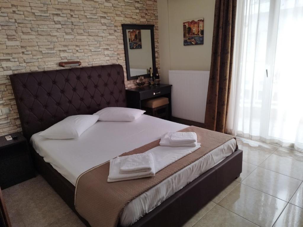 a bedroom with a large bed with towels on it at Hotel Villa Pigasos in Paralia Katerinis