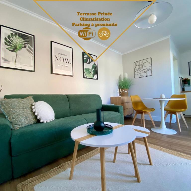 un salon avec un canapé vert et une table dans l'établissement Studio pour deux avec terrasse aux portes de la Camargue, à Aigues-Mortes