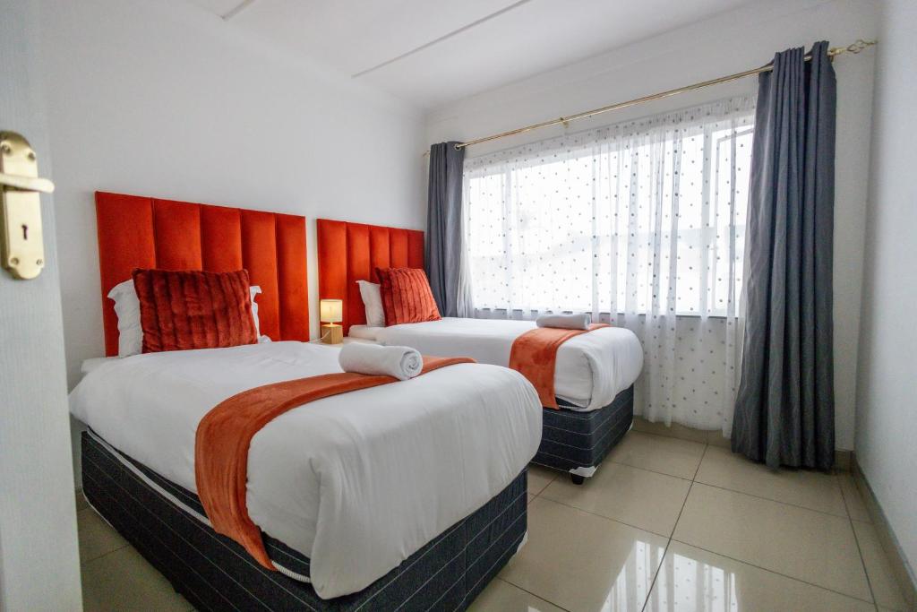 Una habitación de hotel con dos camas y una ventana. en Safi Luxury Apartment 6 - 2 bedroom, en East London