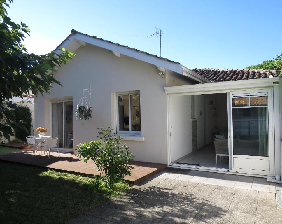 une maison blanche avec une porte coulissante en verre dans l'établissement Maison Flots & Sel 6 personnes proche plage, à Andernos-les-Bains