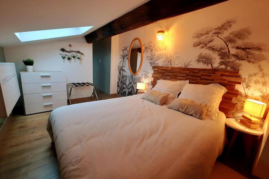 une chambre avec un grand lit blanc et un miroir dans l'établissement Grand appartement proche métro avec climatisation, à Lyon