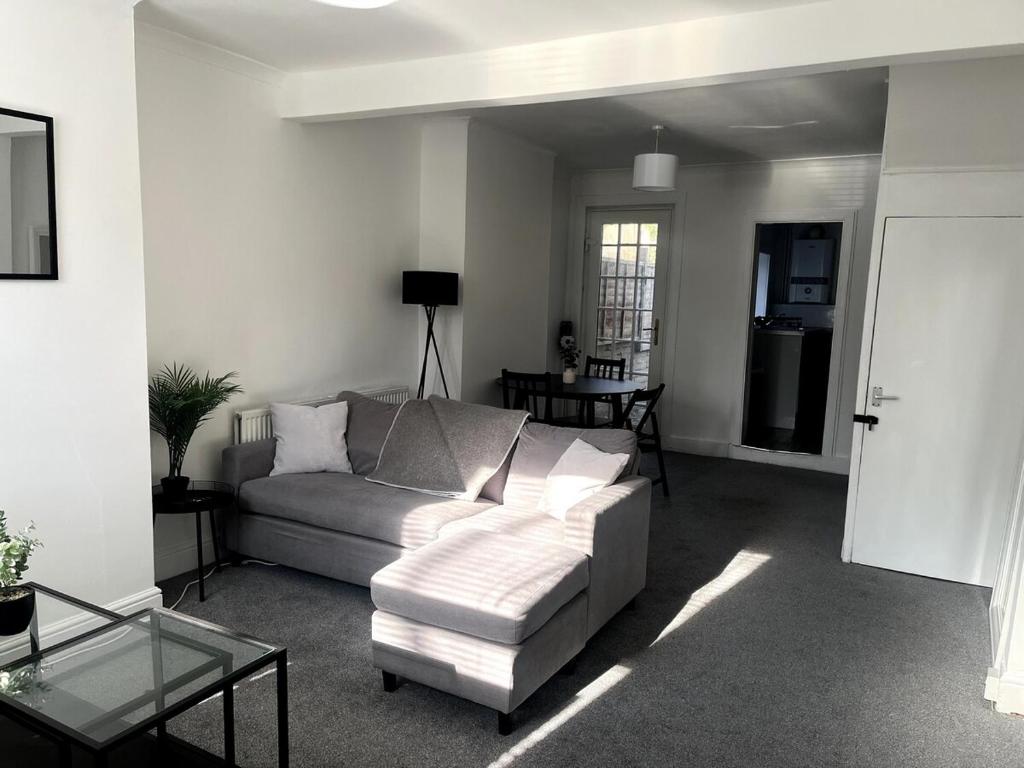 a living room with a couch and a table at Cosy 2-Bed Home - Central Location Near Town & Train Station in Dartford