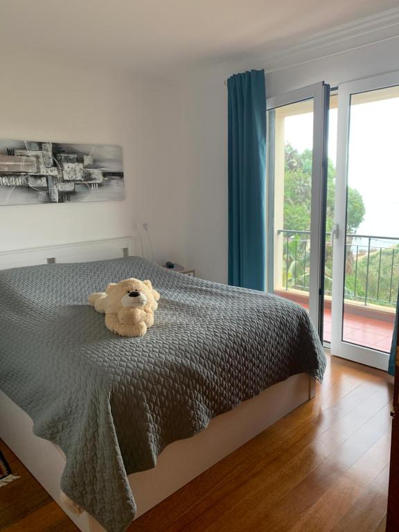 カニコにあるOcean View Condoの寝室のベッドに座るテディベア