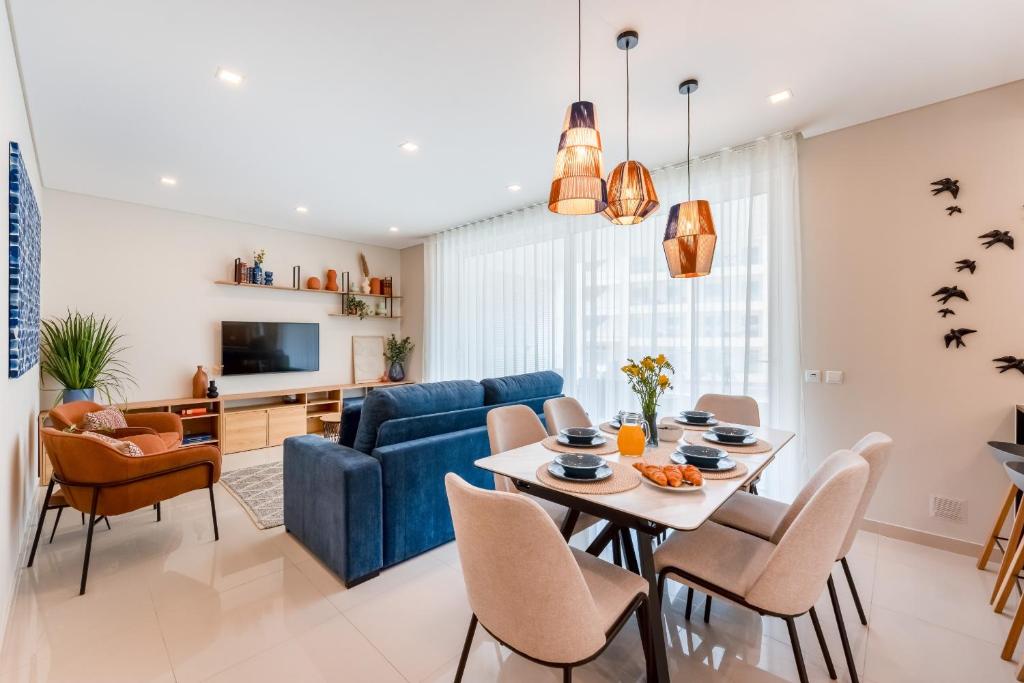 ラゴスにあるAdega luxury Lagos Apartment by Algarve Golden Propertiesのリビングルーム(青いソファ、テーブル、椅子付)