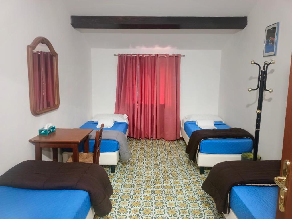 a room with four beds and a table in a room at Niam House in Rome