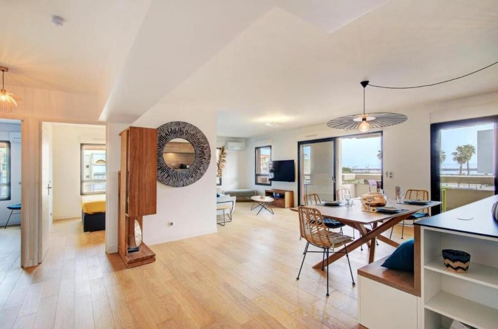 un salon avec une table et une salle à manger dans l'établissement Le Royal Mer -Clim et Parking-, à Sète