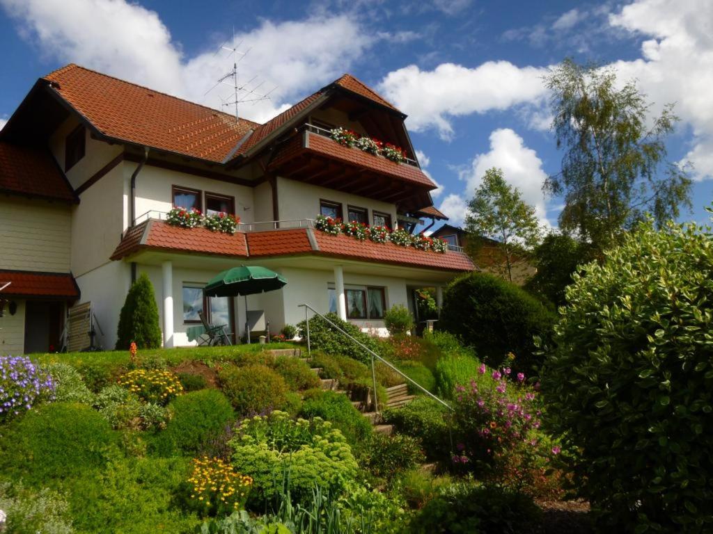 una casa con un jardín de flores delante de ella en Haus Kandelblick, en Furtwangen