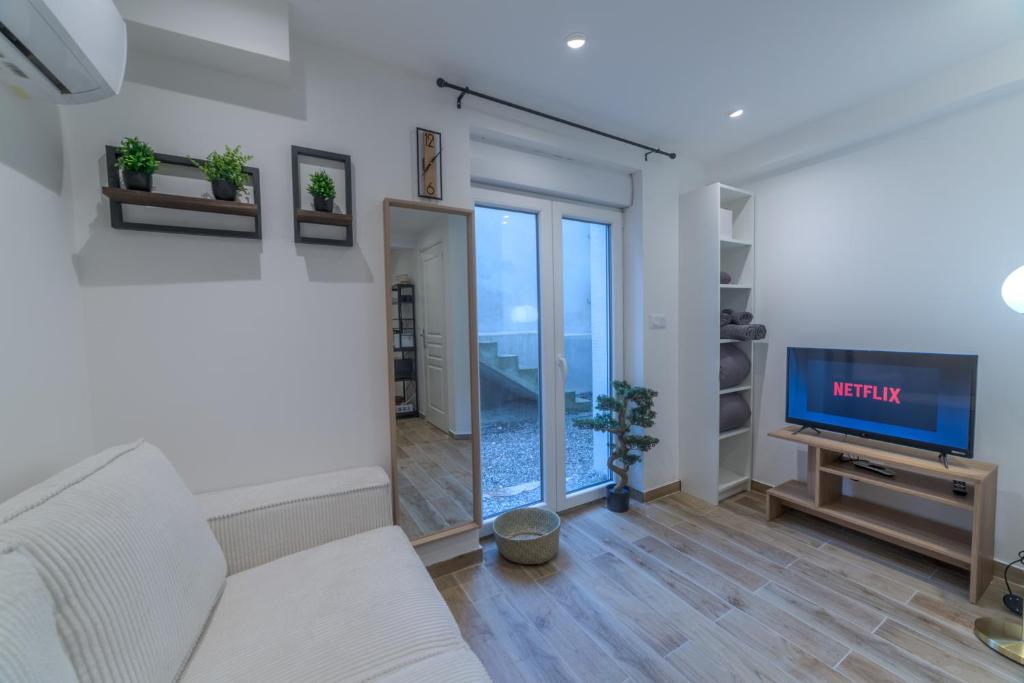un salon avec un canapé et une télévision dans l'établissement Pasteur Collection - Cosy & Charmant 2pers, à Villeurbanne