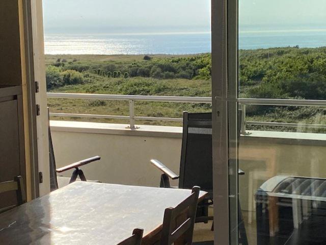 une pièce avec une table et une vue sur l'océan dans l'établissement Vue mer Les Brisants Wimereux, à Wimereux