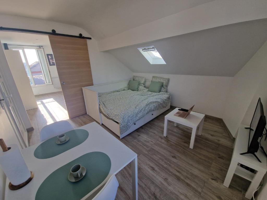 une petite pièce avec un lit et une table dans l'établissement Cosy F2 à Argenteuil Idéal séjour pro ou détente, à Argenteuil