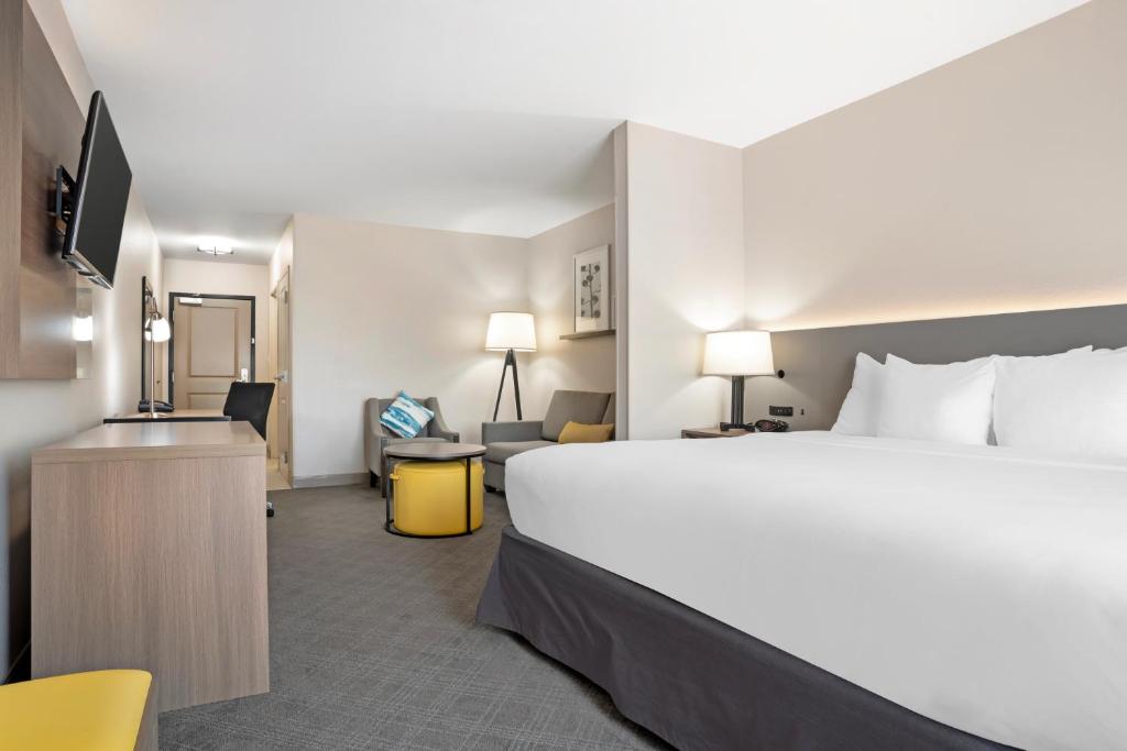 Una habitación de hotel con una cama grande y un escritorio. en Comfort Inn &amp; Suites, en Slidell