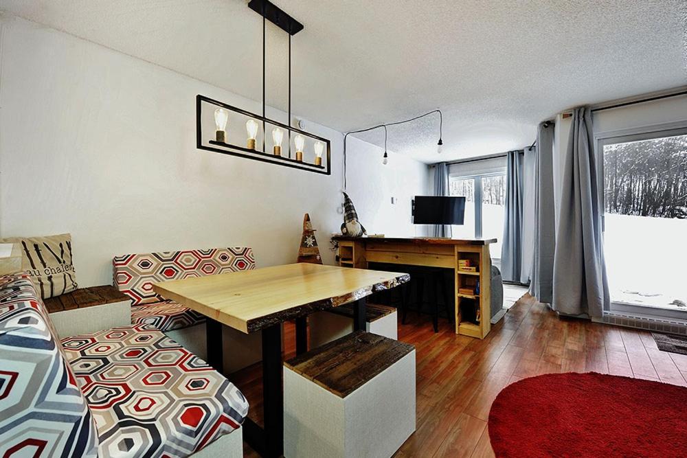 a living room with a wooden table and a desk at Hameau 28-51 Studio in Stoneham