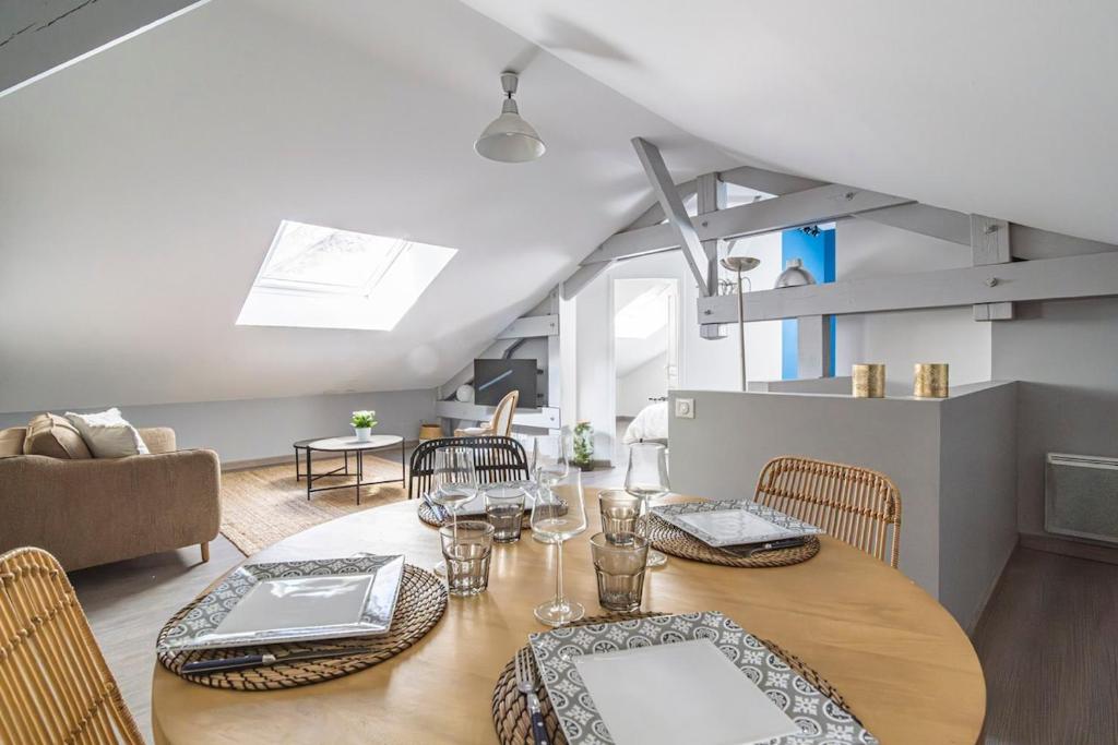 a dining room with a wooden table and chairs at La Suite Vernouillet in Reims