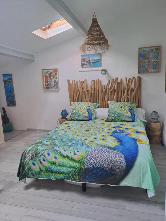 une chambre avec un lit avec une couette colorée dans l'établissement Appartement typique 2 étoiles avec clim, à Collioure