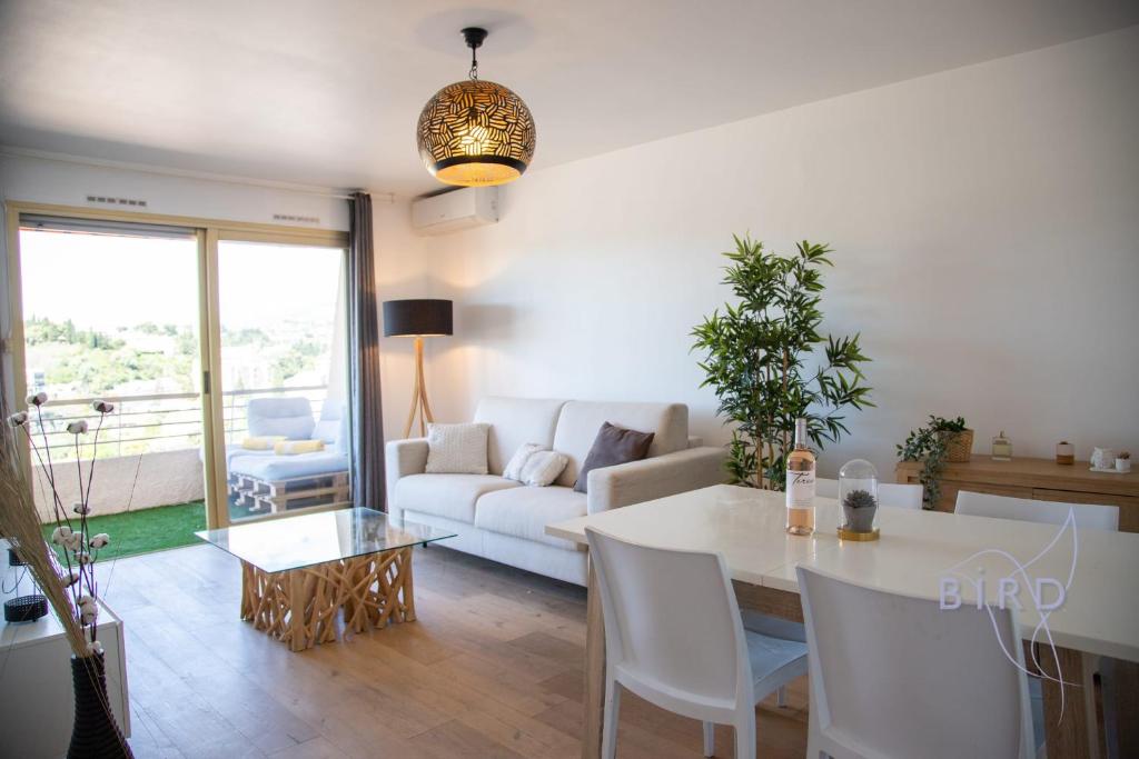un salon avec une table et un canapé blanc dans l'établissement Beautiful Apartment with Terrace AC and PARKING, au Cannet