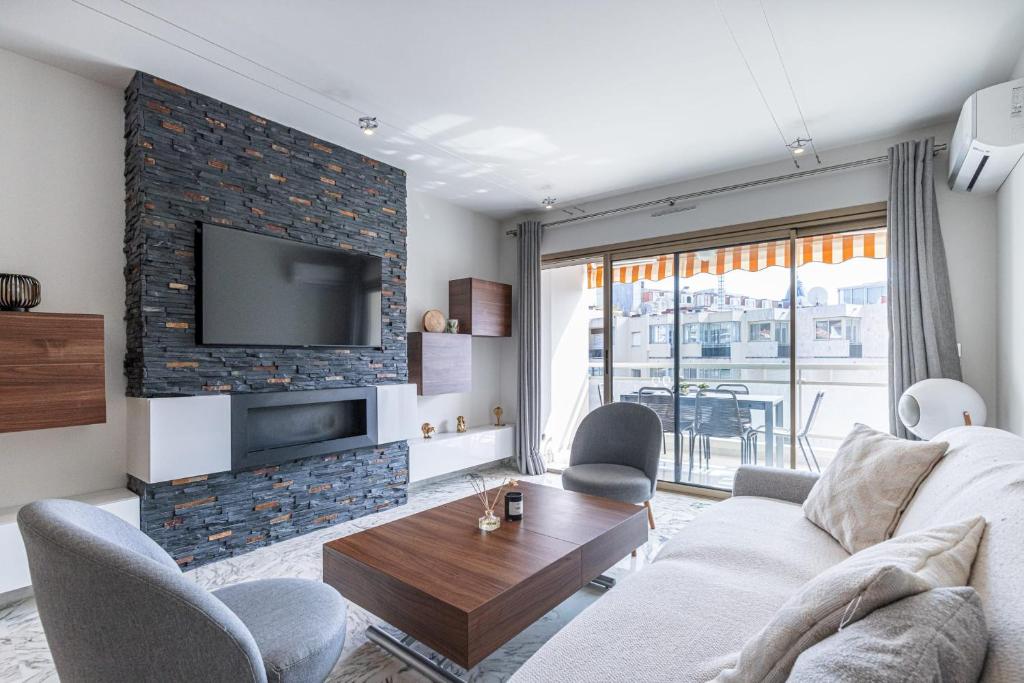 un salon avec un canapé et une télévision dans l'établissement 3 High-End Rooms Central, à Cannes