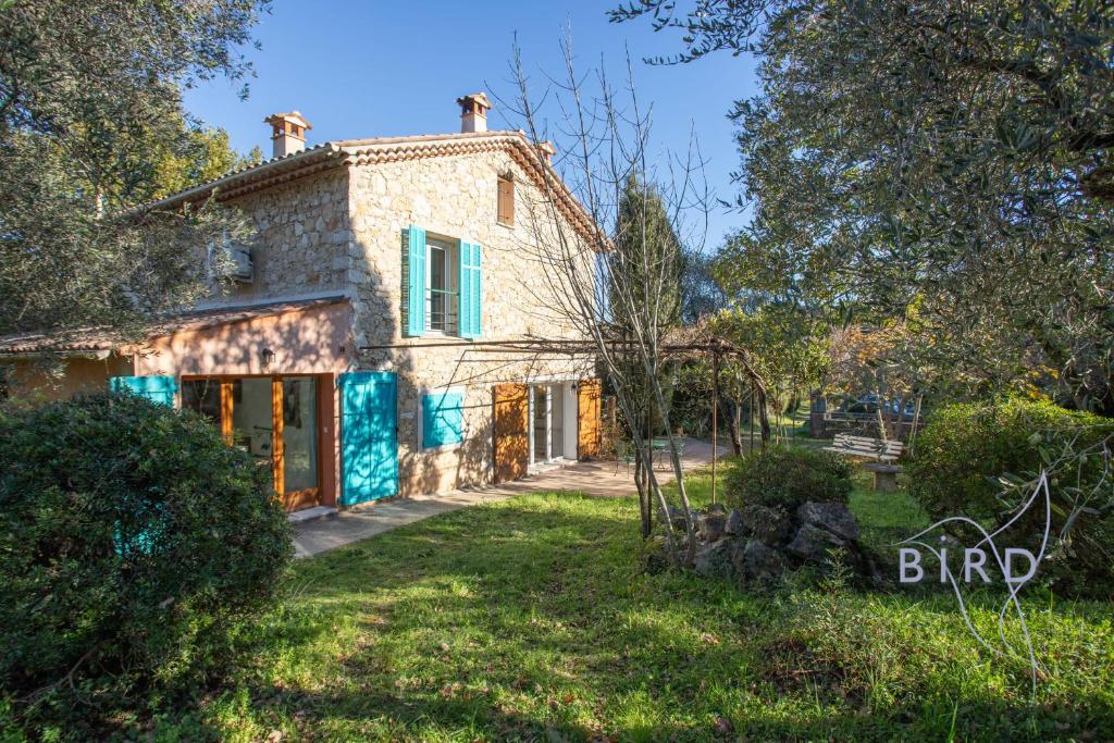 una vista exterior de una casa de piedra con puertas azules en Charming Provencal family home, en La Tour