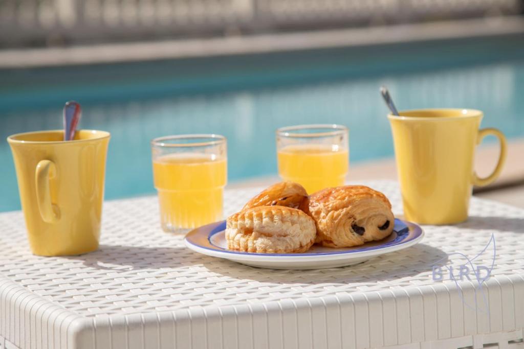 une assiette de pâtisseries sur une table avec deux tasses de jus d'orange dans l'établissement Haven of peace in the Var, à Trans-en-Provence