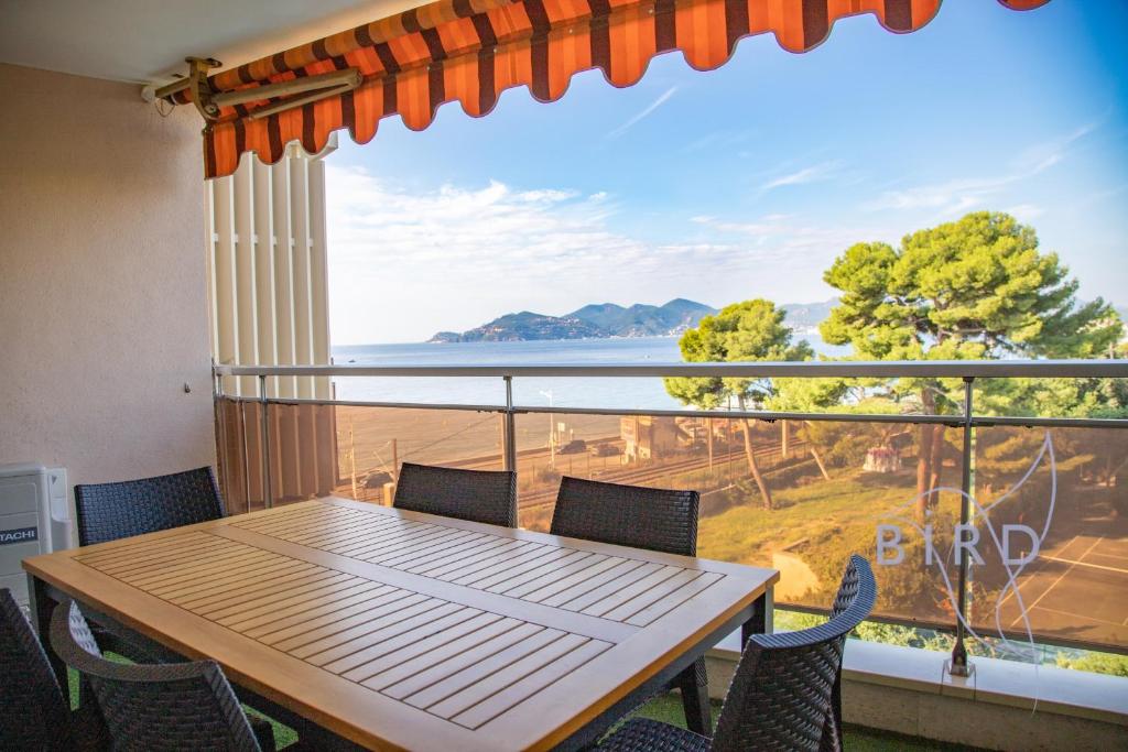 une table et des chaises sur un balcon avec vue sur l'océan dans l'établissement Vue Mer et Esterel Cannes just next to the beach, à Cannes