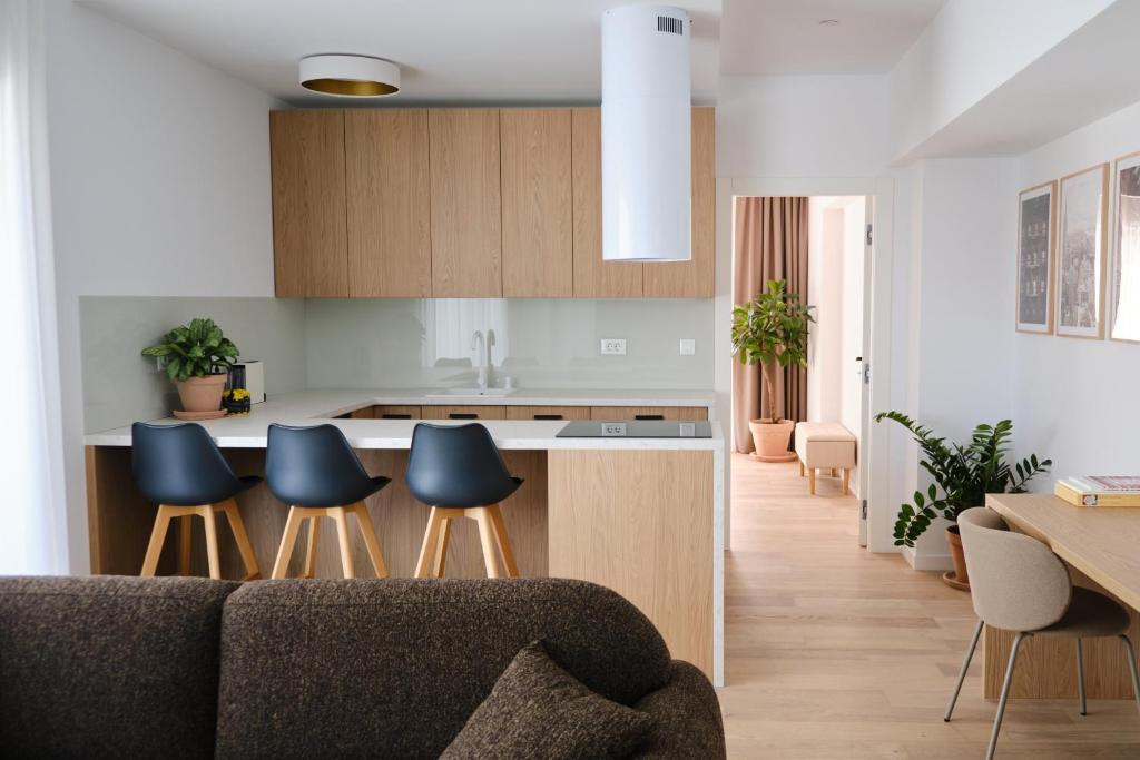 - une cuisine avec un canapé et des chaises dans la chambre dans l'établissement Brown I One Bedroom Apartment I One Cotroceni Park, à Bucarest