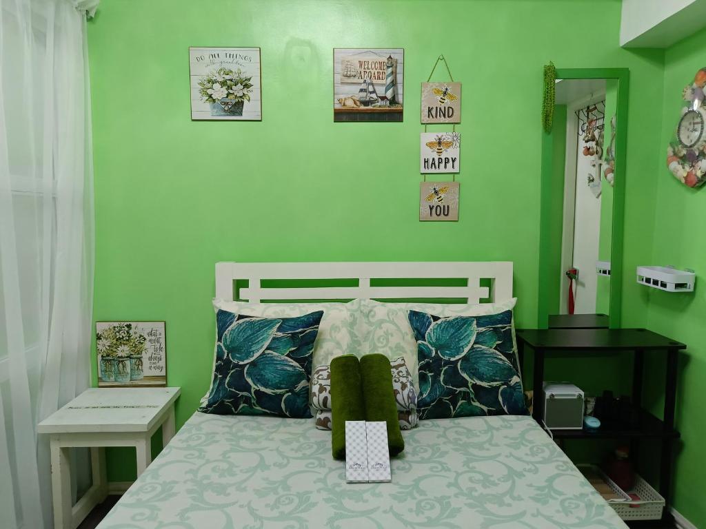 a bedroom with a bed with green walls at Uncle's Tagaytay Staycation in Iruhin
