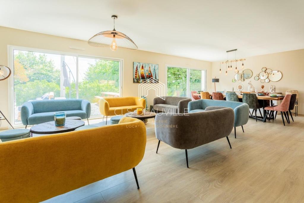 - un salon avec des canapés, des tables et des chaises dans l'établissement Villa Saint Martin - 23 couchages, à Saint-Martin-aux-Chartrains