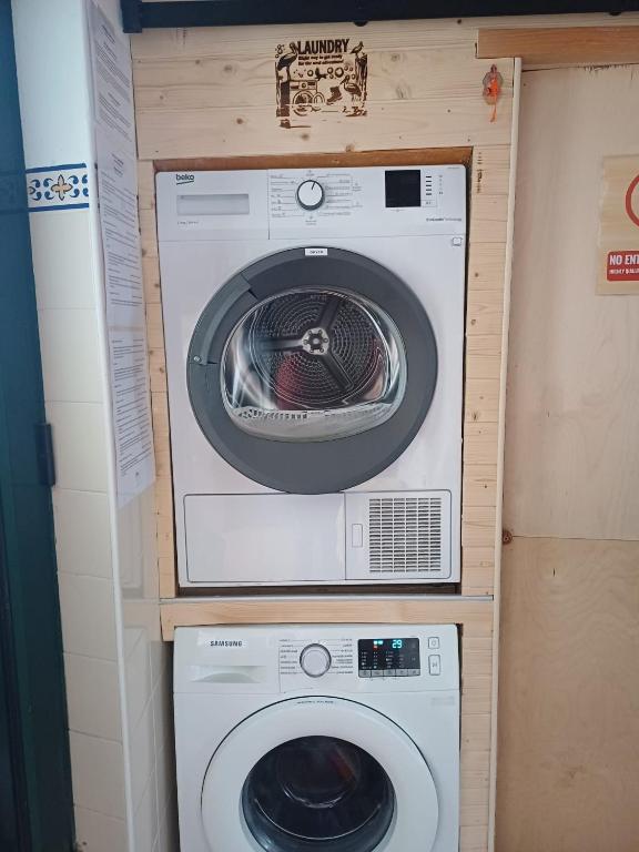 two washing machines and a washer and dryer in a room at Hostel Nature in Zambujeira do Mar