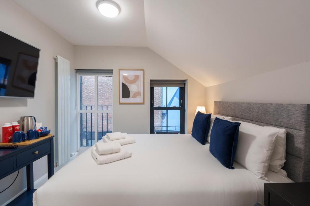 una camera da letto con un grande letto bianco con cuscini blu di The Temple Bar Lane a Dublino