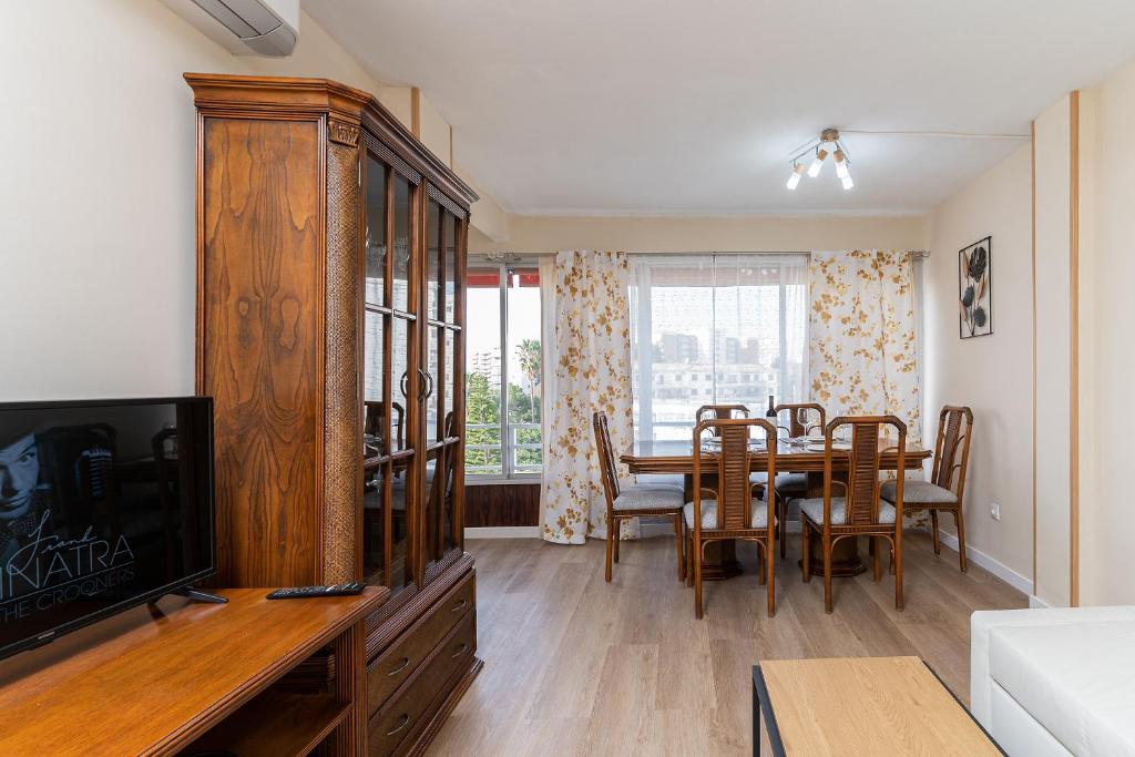 una sala da pranzo con tavolo, sedie e televisione di Golden Sunset a Benalmádena