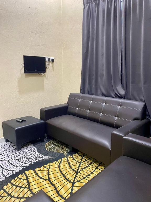 a living room with a couch and a curtain at Rumah Tamu Tok Abah, Alor lintang in Kampung Raja