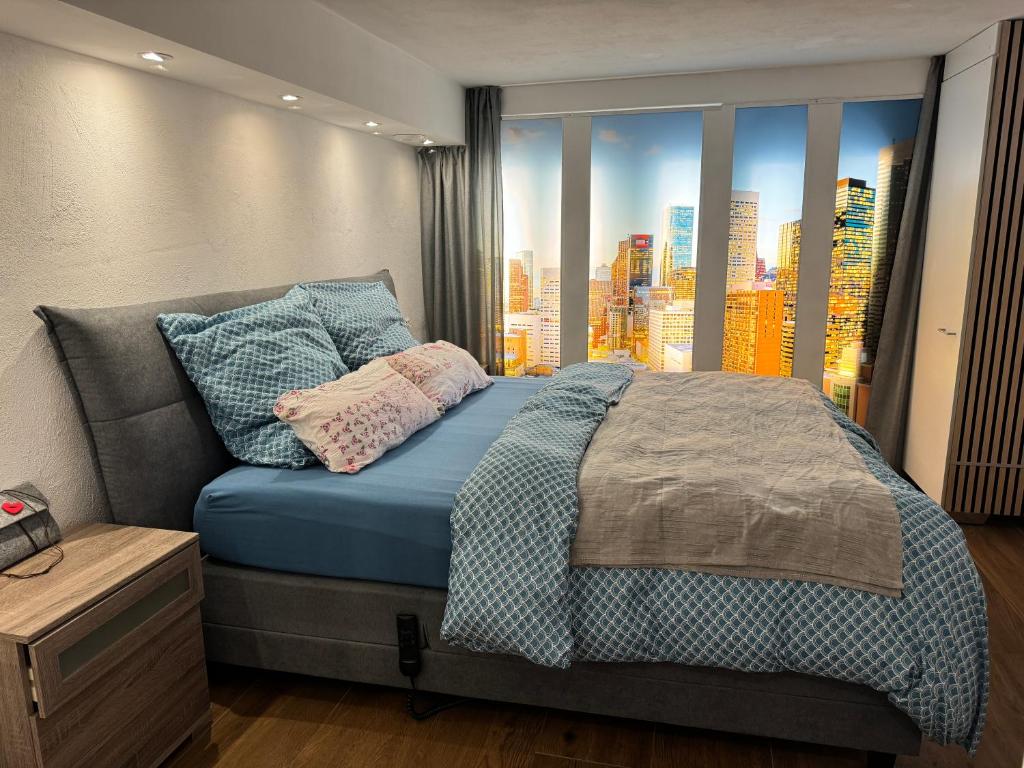 a bedroom with a bed with a view of a city at Schöne Souterrain Wohnung in Herzogenrath mit Sauna! in Herzogenrath