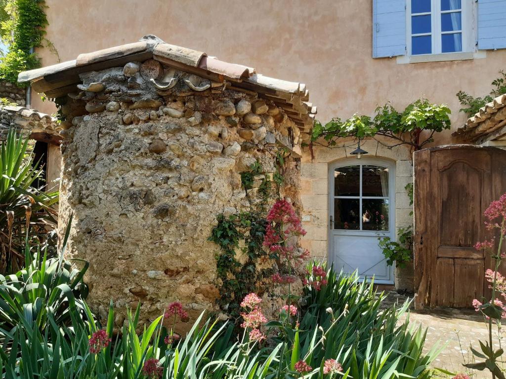 une maison en pierre avec une porte et des fleurs dans l'établissement Le Midi, A Refined Master House in Provence with a swimming pool, à Valensole