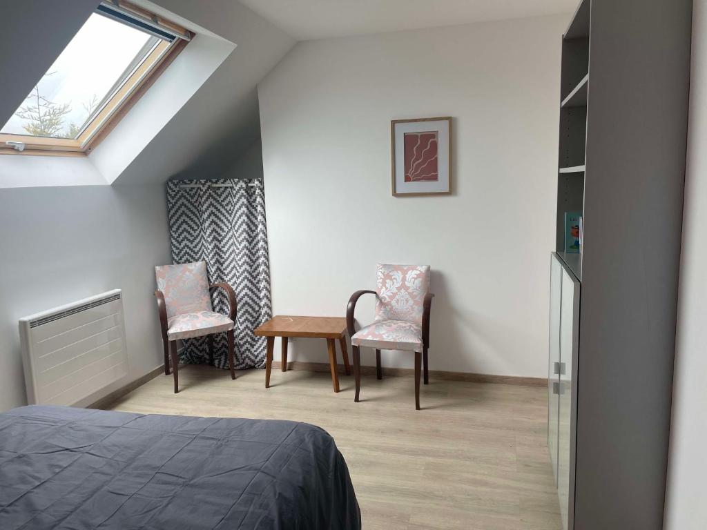 - une chambre avec 2 chaises, une table et une fenêtre dans l'établissement Charmante maison familiale au Pouliguen, au Pouliguen