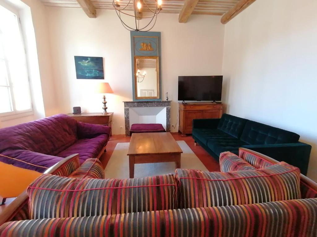 ein Wohnzimmer mit zwei Sofas und einem Fernseher in der Unterkunft Croassecorbeau Maison de Famille au pied du Ventoux in Malaucène