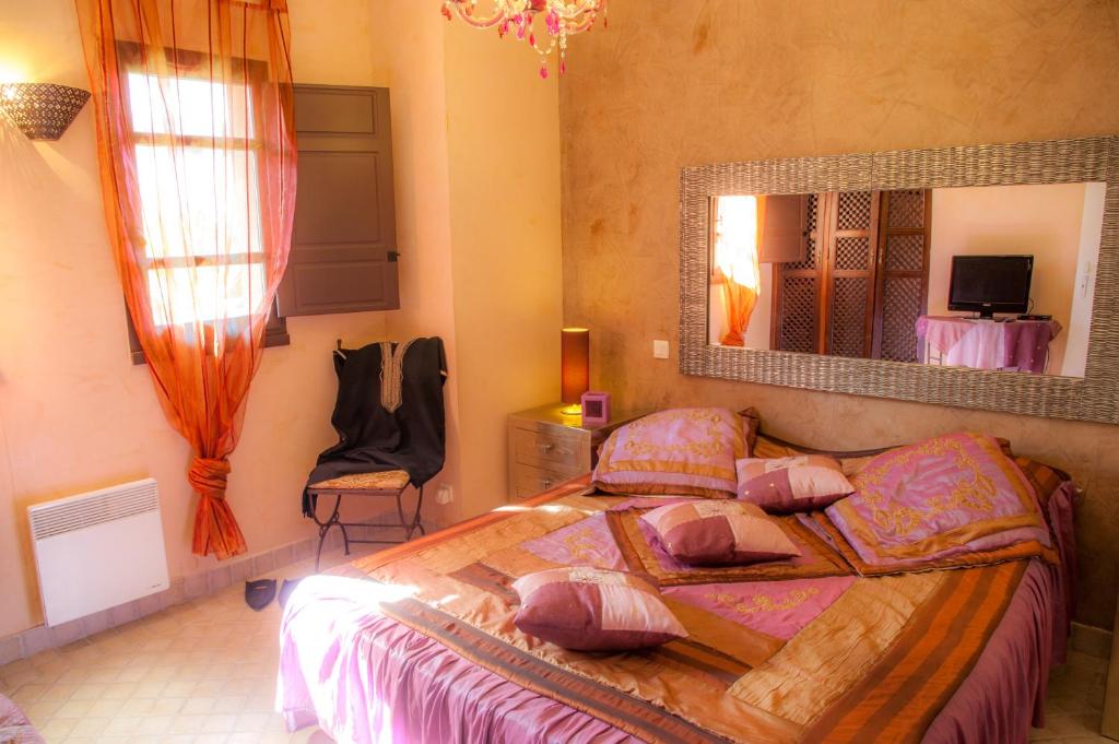 une chambre avec un grand lit et un miroir dans l'établissement Suite Bradia, Riad 2 Couple only au village naturiste, au Cap d'Agde