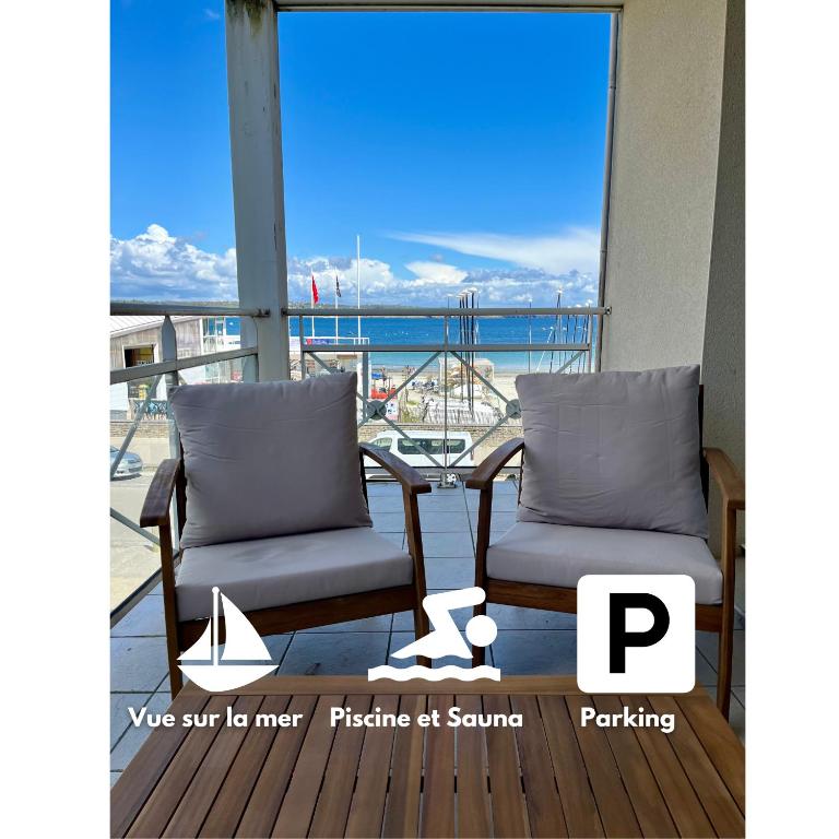 - deux chaises sur un balcon avec vue sur l'océan dans l'établissement Appartement Cosy, terrasse vu mer, piscine, Sauna - WarmHouse, à Plougonvelin