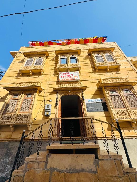 a yellow building with a sign on it at Happy Trails Jaisalmer in Jaisalmer