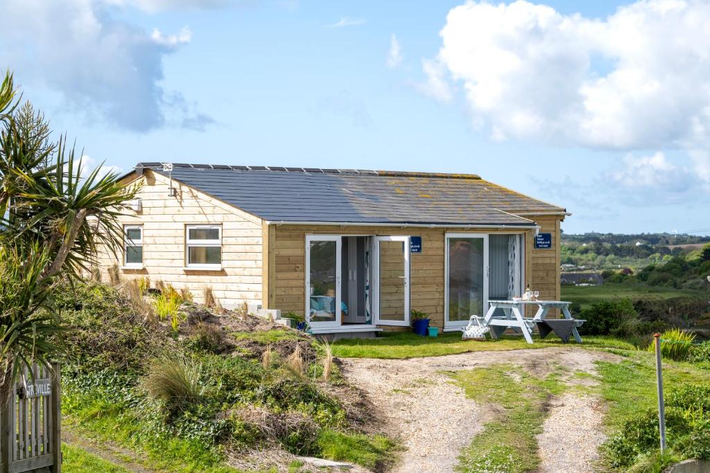 a tiny house on a hill with a gravel driveway at WestHill Beach Chalet, Riviere Towans in Hayle