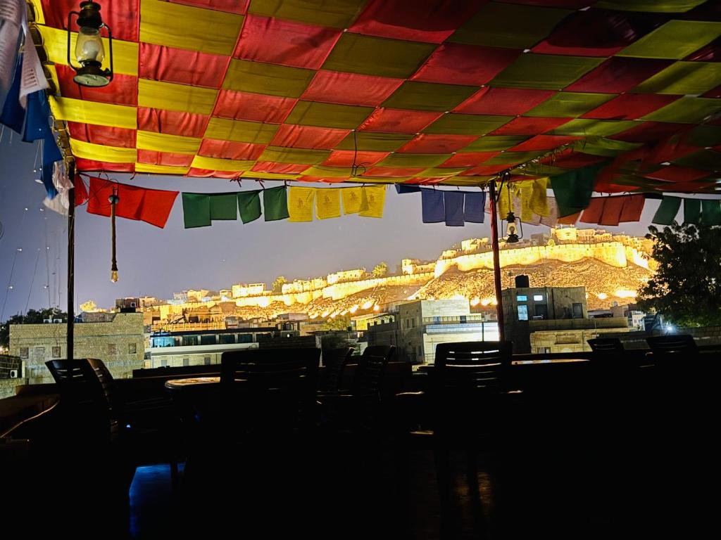 a group of chairs under a colorful umbrella at Happy Trails Jaisalmer in Jaisalmer