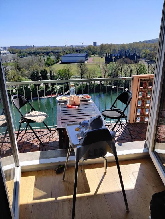 un patio avec une table et des chaises sur un balcon dans l'établissement Le nid de la Garonne, à Toulouse