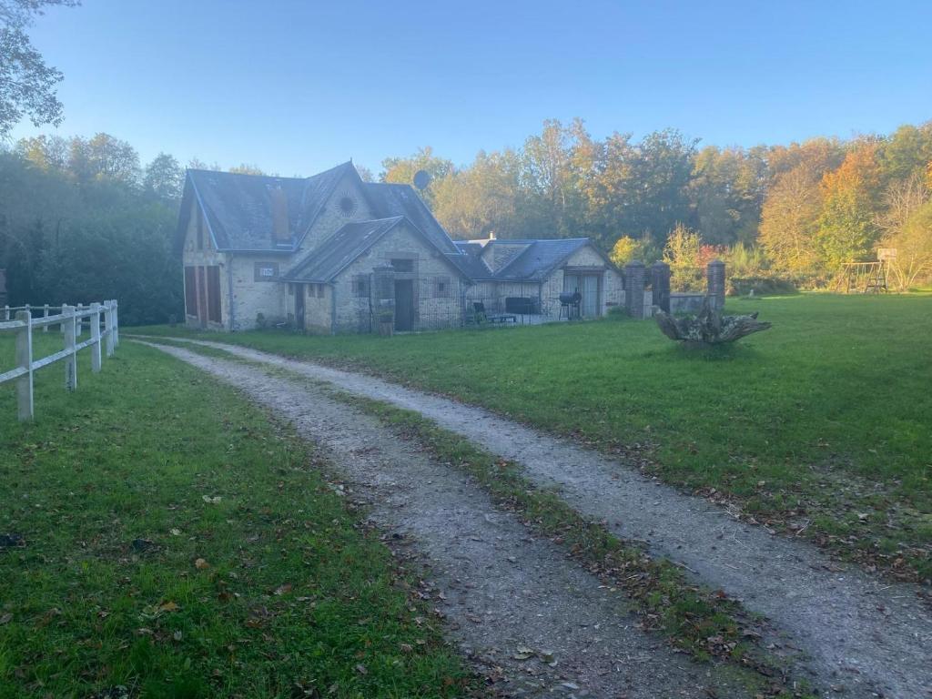 une maison sur un champ avec un chemin de terre dans l'établissement Bob Dylan, à Raizeux