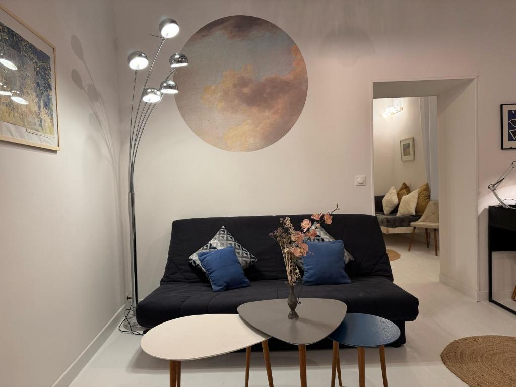 un salon avec un canapé noir et une table dans l'établissement Marche aux Fleurs - Premiere conciergerie, à Montpellier