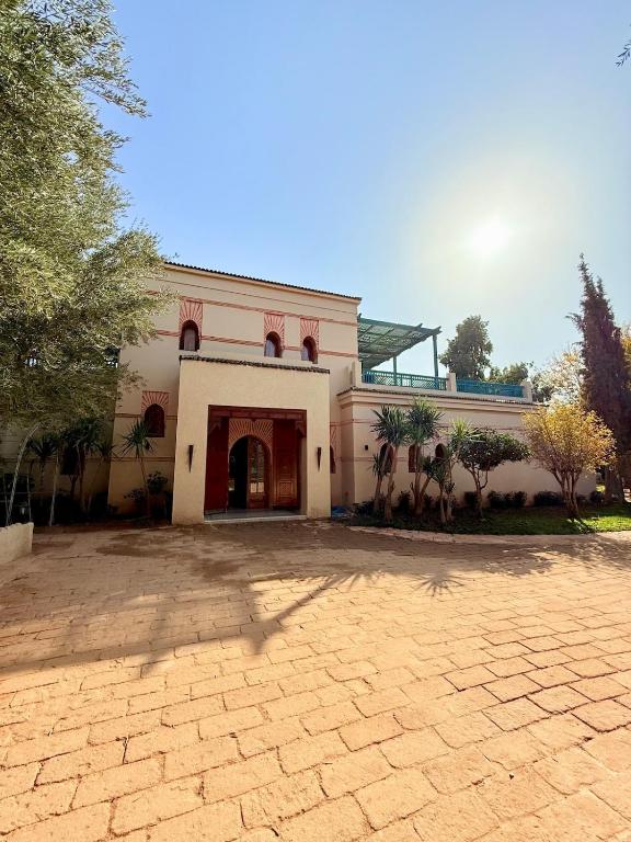a large white building with a driveway in front of it at VILLA 34 - 4 Masters, Moroccan Charm & Modern Comfort with Private Pool in Marrakesh